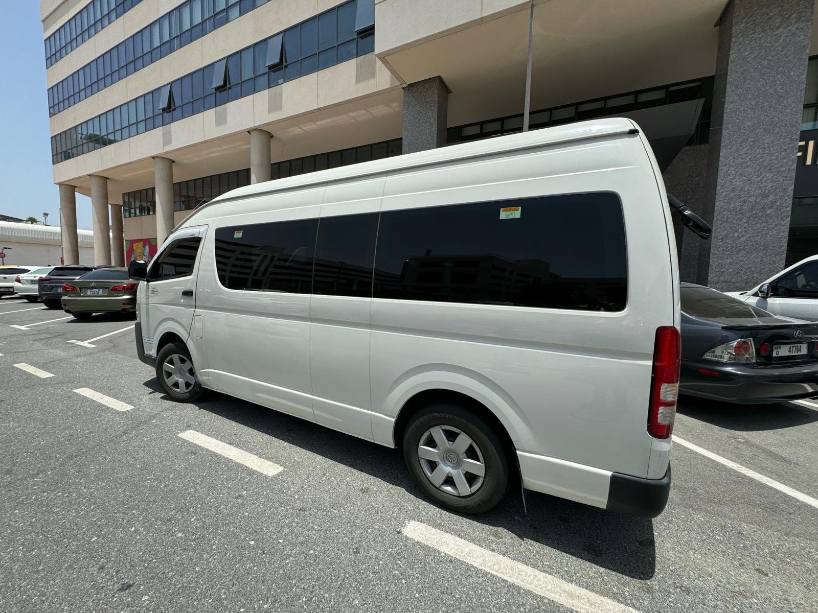 Illustrative Toyota Hiace passenger van image — 14-seat class